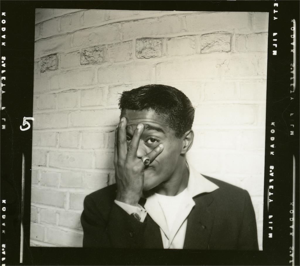Sammy Davis Jr. covering his face with his left hand